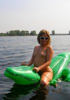 Краля в солнцезащитных очках голышом позирует во время отдыха на озере 7 фото