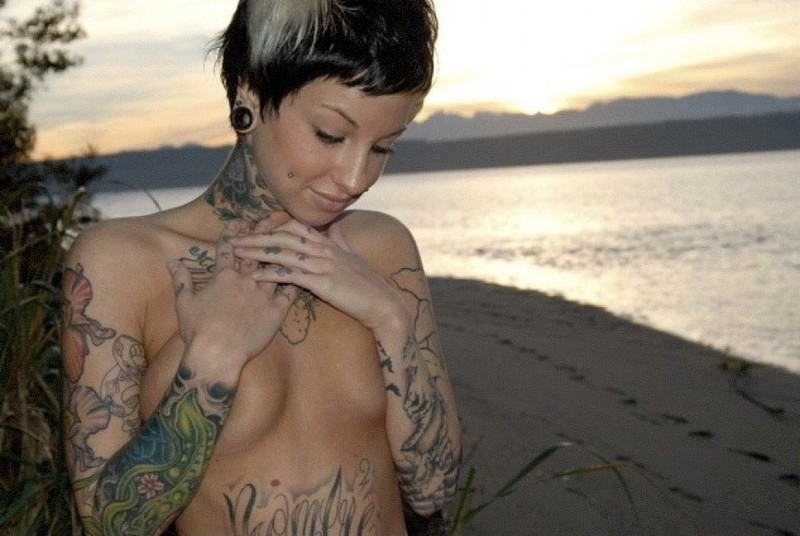 Татуированная неформалка позирует топлес на берегу водоема 1 фотография